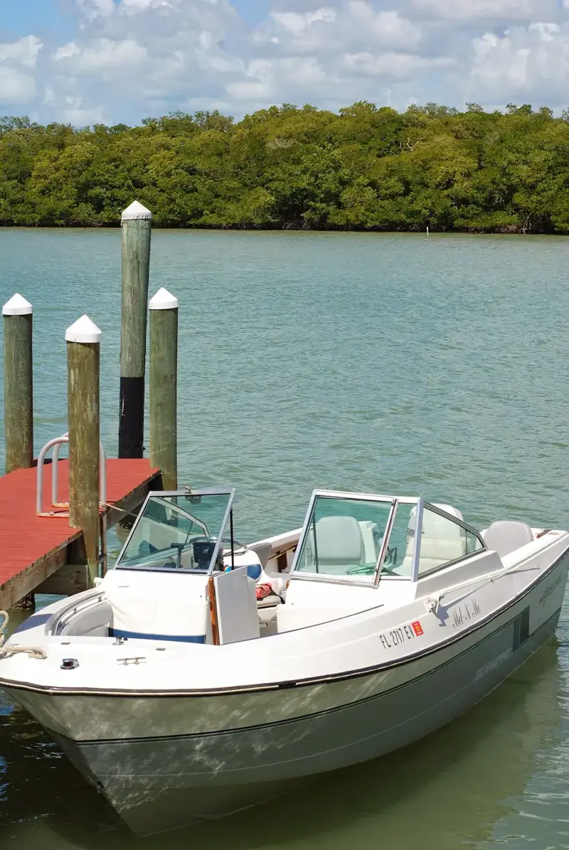 A boat at a dock in Goodland, Florida, with mangroves behind it