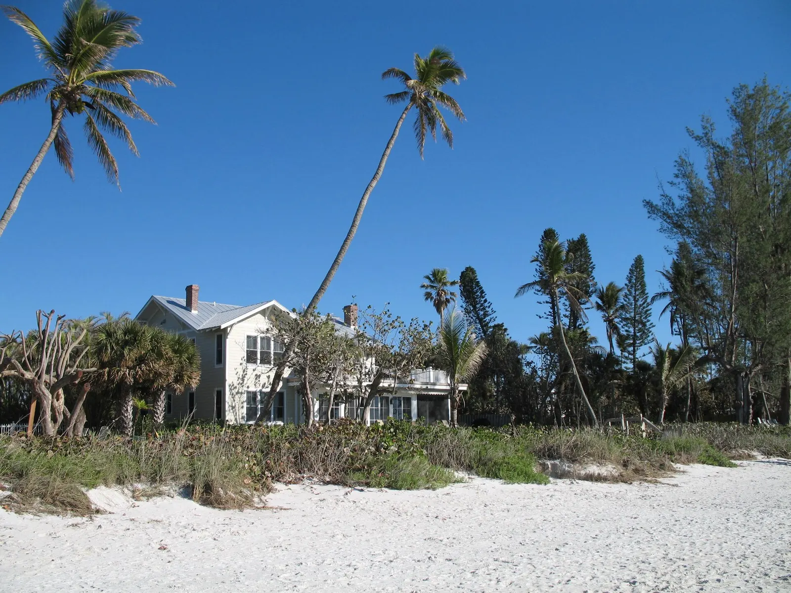 Naples beach in bright sun, with the pier in the distance