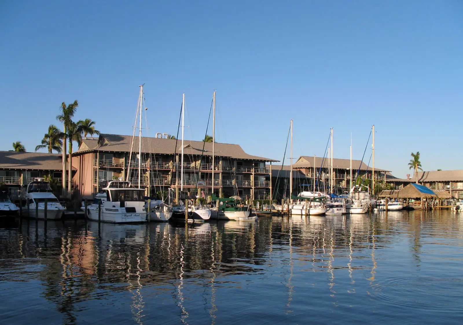 Boats docked at Naples City Dock under a blue sky